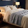 DeepHold Weighted Blanket draped across a bed in evening light
